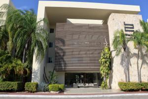 un bâtiment avec des palmiers en face de celui-ci dans l'établissement Marina Excelsior, à Playa del Carmen