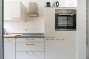a white kitchen with white cabinets and a stove at Zentrales Apartment am Nordertor in Flensburg