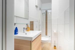 a white bathroom with a sink and a toilet at Zentrales Apartment am Nordertor in Flensburg