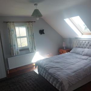 sypialnia z łóżkiem i 2 oknami w obiekcie Kenmare w mieście Kenmare
