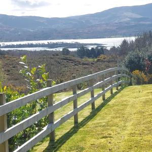 a fence on a hill with a view of a lake at Kenmare in Kenmare