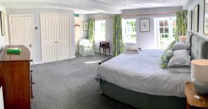 a bedroom with a large bed and a chair at The Mill House in Santon