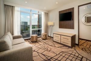 a living room with a couch and a flat screen tv at Hilton Garden Inn Bogota Airport in Bogotá