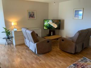 a living room with two chairs and a flat screen tv at Ocean view apartment in Galway