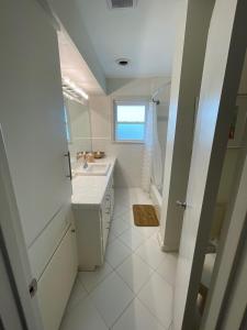 休斯頓的住宿－The Royal Room at Galleria，白色的浴室设有水槽和窗户。