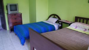 um quarto com 2 camas e uma televisão numa cómoda em Zumag Sisa em Tena