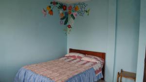 a bedroom with a bed with a flower mural on the wall at Zumag Sisa in Tena