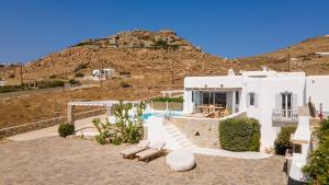una casa bianca con una collina sullo sfondo di Ocean Blue Villa by LLB - Beach in 6min walking a Mykonos Città
