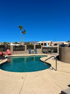 una piscina con 2 sillas y una mesa en Modern Desert Delight! 4- bedrooms, pool, gameroom en Lake Havasu City