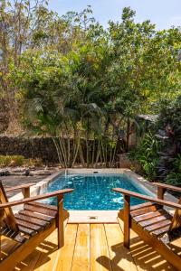 una piscina con 2 bancos en una terraza de madera en Casa Mono del Río en Matapalo
