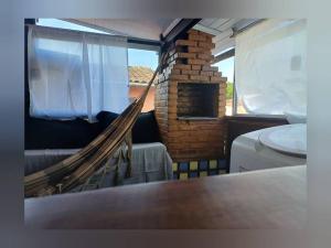 a hammock in a room with a fireplace and a window at Casa Paraty - Centro in Paraty