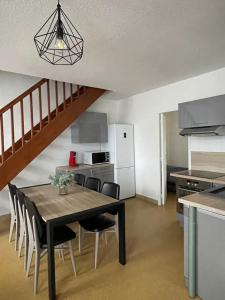 Una cocina y un comedor con mesa y sillas. en Logement familial 3 chambres 2 wc 2 sdb Futuroscope Arena Aquascope Palais des Congrès, en Jaunay-Clan