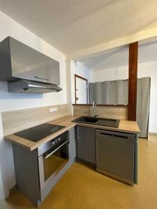 Una cocina vacía con un fregadero y una estufa. en Logement familial 3 chambres 2 wc 2 sdb Futuroscope Arena Aquascope Palais des Congrès, en Jaunay-Clan