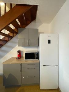 una cocina con nevera blanca junto a una escalera en Logement familial 3 chambres 2 wc 2 sdb Futuroscope Arena Aquascope Palais des Congrès, en Jaunay-Clan