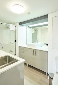 una cocina blanca con armarios blancos y fregadero en River Plaza Apartments Brisbane, en Brisbane