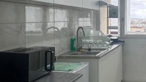 une cuisine avec un évier, une cuisinière et une fenêtre dans l'établissement paris holiday, à Aubervilliers 14 autres photos