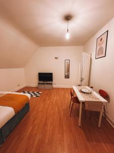 a bedroom with a bed and a table and a television at Spacious 3 rooms in Tooting in London