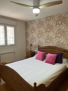 a bedroom with a large bed with two pink pillows at Gorriones in Pelayos de la Presa