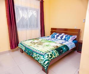 - un lit dans une chambre avec fenêtre dans l'établissement J&G Premier Apartment, à Yaoundé