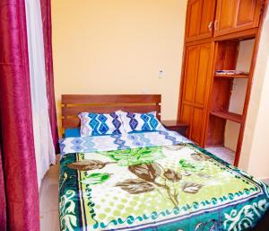 - une chambre avec un lit et une couette colorée dans l'établissement J&G Premier Apartment, à Yaoundé