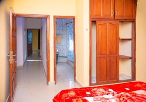 - une chambre avec un lit, une porte et un couloir dans l'établissement J&G Premier Apartment, à Yaoundé