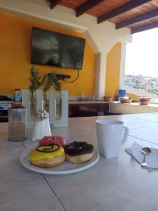 dos donuts en un plato blanco en una mesa en Casa María, en Ensenada