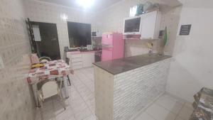 a kitchen with a pink refrigerator and a table at Apartamento em peruibe in Peruíbe