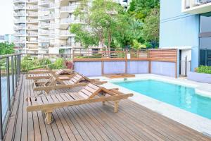 a deck with chairs and a swimming pool on a building at River Plaza Apartments Brisbane in Brisbane
