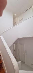 eine weiße Treppe in einem weißen Zimmer mit einer Tür in der Unterkunft Owls Hostel Ribeiro in Porto