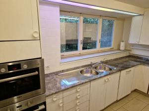 a kitchen with two sinks and a window at CozyWisi holiday home for 1 to 6 people near Technorama 4 bedrooms 2 bathrooms bookable from 2 days in Wiesendangen