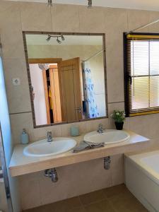 a bathroom with two sinks and a large mirror at Villa 20 in Caleta De Fuste