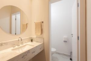 a bathroom with a sink and a mirror and a toilet at THÁI MOTEL in Mogi-Guaçu