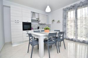 uma cozinha com uma mesa branca e cadeiras em Il cuore di Lavika em Linera