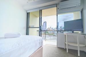 Un dormitorio con una cama y un escritorio con una computadora. en River Plaza Apartments Brisbane Southbank, en Brisbane