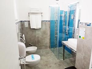 La salle de bains est pourvue de 2 toilettes, d'un lavabo et d'une douche. dans l'établissement Hotel Blu Eden, à Praia a Mare