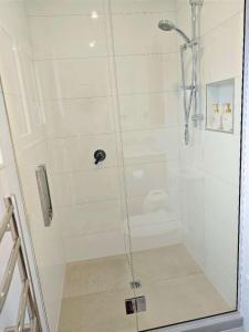 a shower with a glass door in a bathroom at LilyのHome Elegant Retreat near Riccarton Mall in Christchurch