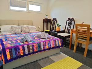 sypialnia z łóżkiem, stołem i krzesłami w obiekcie LilyのHome Elegant Retreat near Riccarton Mall w mieście Christchurch