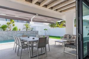 a patio with a table and chairs and a pool at VILLA caracolillo MAR in Chiclana de la Frontera