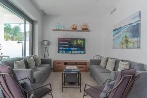a living room with a couch and chairs and a tv at VILLA caracolillo MAR in Chiclana de la Frontera