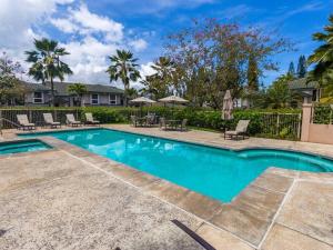 a swimming pool in a yard with chairs and trees at Villas of Kamalii 37 in Princeville