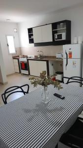 eine Küche mit einem Tisch und einer Blumenvase darauf in der Unterkunft LA ESTACION in Gualeguaychú