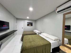 聖路易斯的住宿－Edifício Creta，酒店客房设有两张床和一台平面电视。