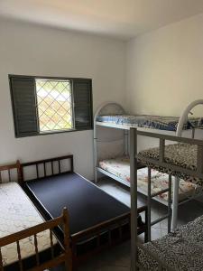 een kamer met 3 stapelbedden en een raam bij Meu Pequeno Paraíso in Pinhalzinho