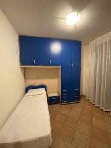 una piccola camera con armadi blu e un letto di Holiday home in Isola di Albarella 49974 a Palazzo Vianello
