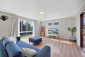 a living room with a blue couch and a chair at The Hideaway in Bargara