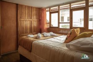 a bedroom with two beds and two windows at BEAUTIFUL, SPACIOUS & COZY HOUSE LOCATED IN THE HEART OF CUSCO in Cusco