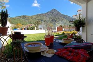 una mesa con comida y vistas a la montaña en Casa imperial Estancia Verde, Biotopo del Quetzal, en Purulhá