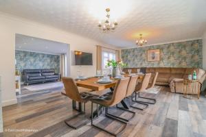 a dining room with a table and chairs and a couch at Large villa sleeping 8 under 5 minute walk to beach in Caister-on-Sea