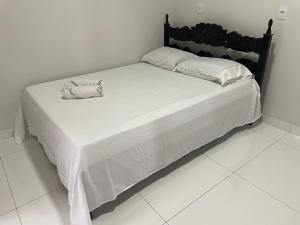 a large white bed with white sheets and pillows at Cama & Café Parecis in Campo Novo do Parecis