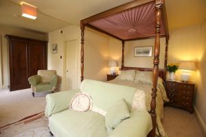a bedroom with a canopy bed and a couch at The Cornmill in Kirkbymoorside +12 photos